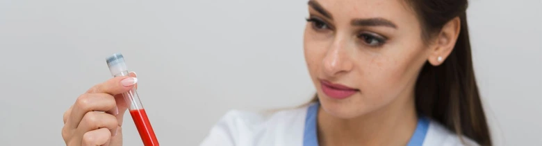 Žena drží zkumavku s krví pro laboratorní vyšetření.