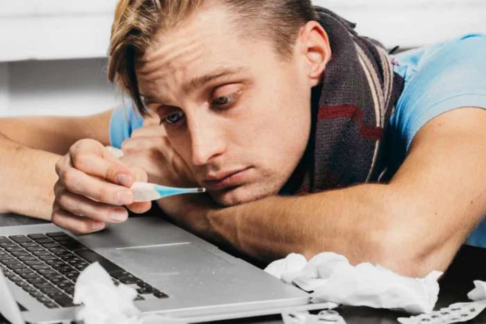 Man with thermometer and laptop