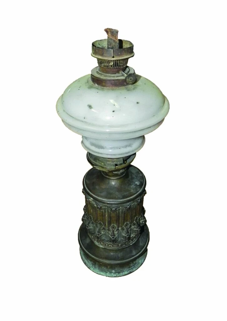 Stará petrolejová lampa s bronzovým podstavcem a skleněným stínidlem.