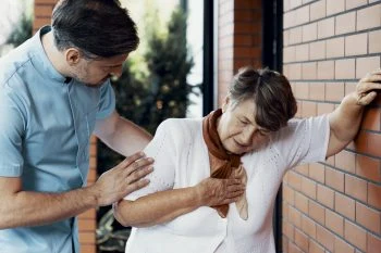 Man helping woman with chest pain