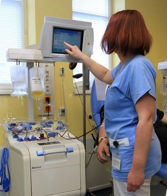 Zdravotní sestra pracuje u přístroje pro transfuzi krve.