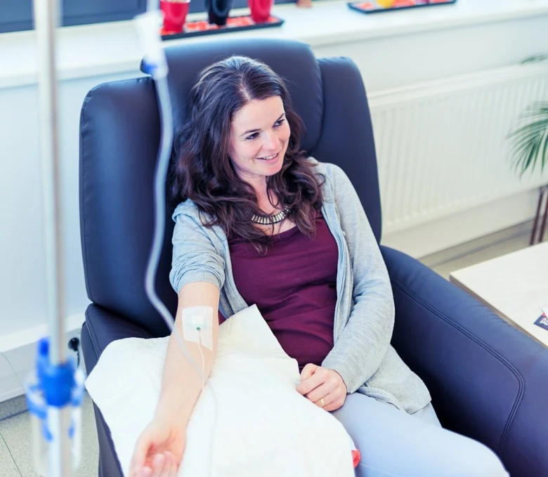 Žena dostává infuzi v křesle během léčby.