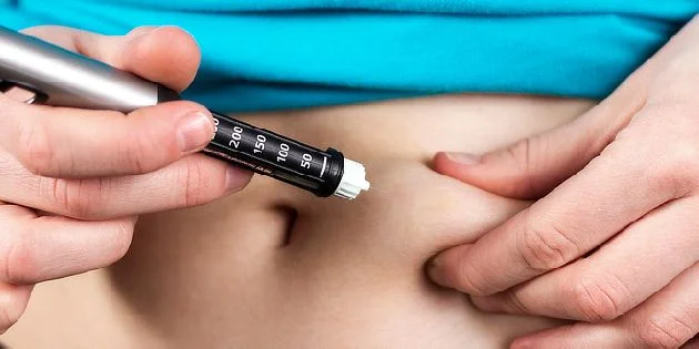 Inzulínová injekce do břicha při léčbě cukrovky.
