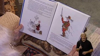 Otevřená dětská kniha s ilustracemi pohádkových postav.