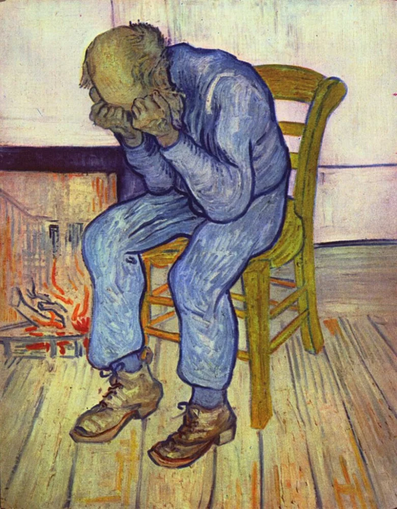 Muž sedící u krbu s rukama na obličeji.