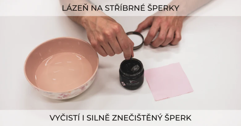Člověk čistí stříbrný šperk černou pastou na bílém povrchu.