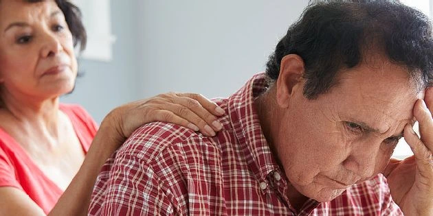 Žena utěšuje starého muže s demencí v emocionálním rozpacích.
