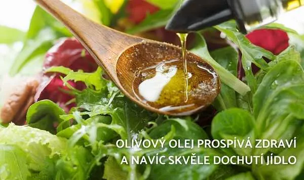 Olivový olej se lije na čerstvý salát z listových zelenin.