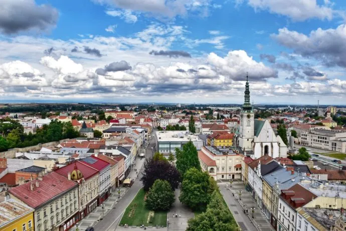 Pohled na náměstí v Plumlově s kostelem a historickými domy.