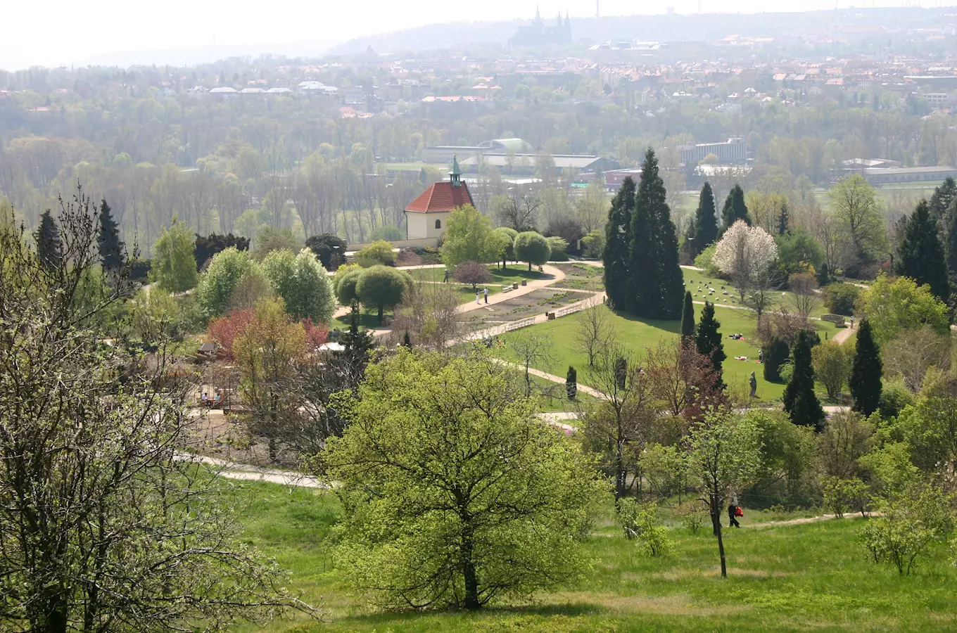 Botanická zahrada v Praze s cestami a stromy na pozadí města