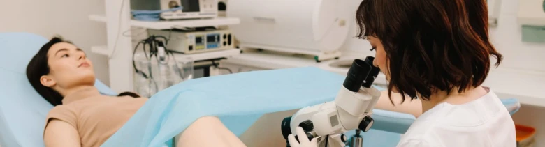 Žena lékařka zkoumá pacientku kolposkopem v ordinaci.