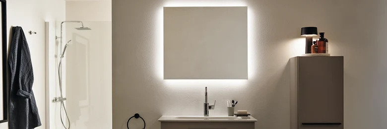 Moderní koupelna s osvětleným zrcadlem pro vizuální zvětšení prostoru