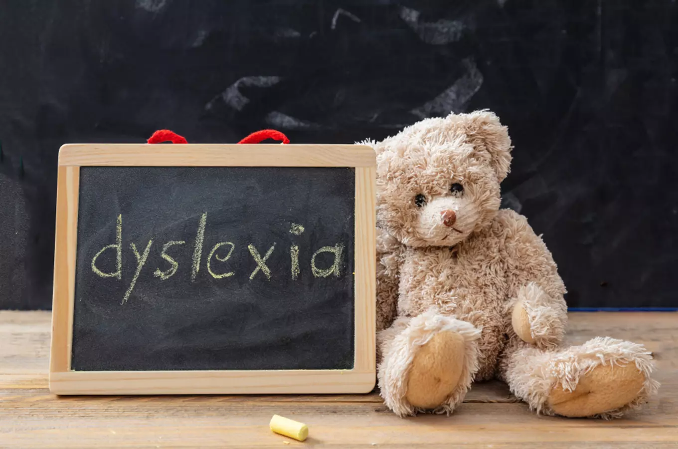 Medvídek s tabulkou psaným slovem dyslexie.