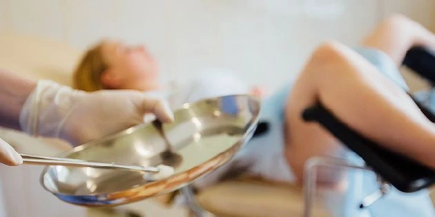 Příprava na kyretáž s lékařskými nástroji u pacientky v ordinaci.
