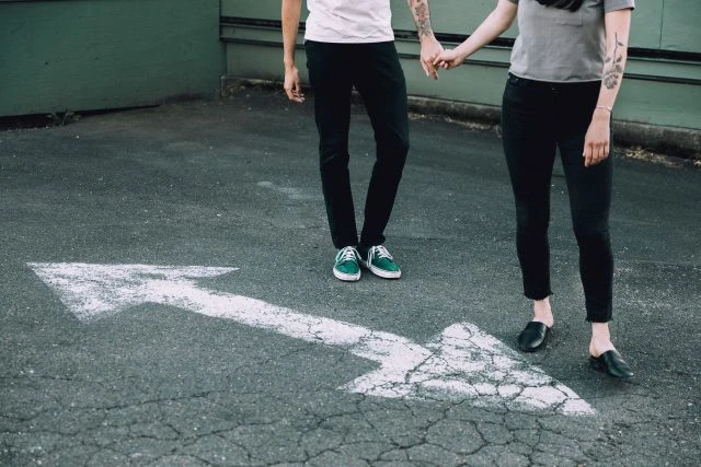 Couple holding hands on pavement