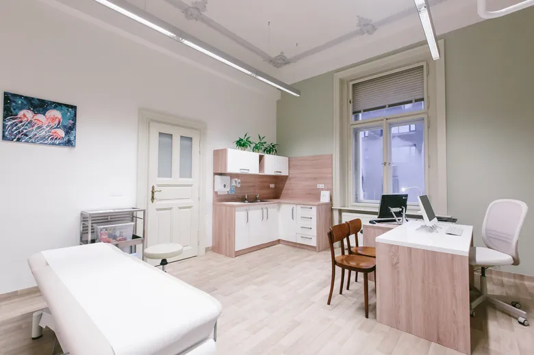 Moderní lékařská ordinace s vyšetřovacím stolem pro pacienty.