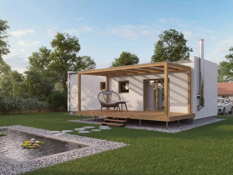 Moderní modulový dům s terasou v zeleném zahradním prostředí.